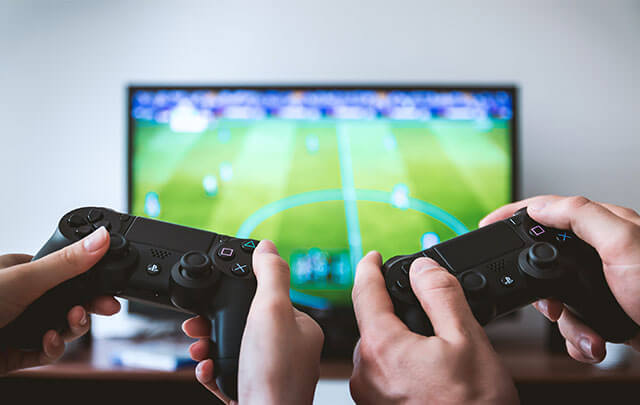 Man and woman playing soccer video game keeping busy instead of drinking.