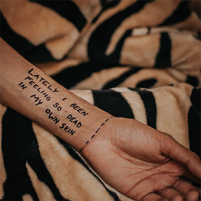 "Lately I been feeling so dead in my own skin" written in black sharpie marker
